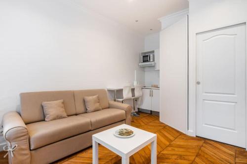 un salon avec un canapé et une table dans l'établissement Studio Luxe Montaigne, à Paris