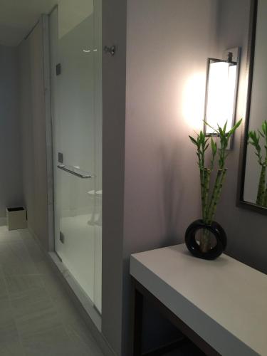 a bathroom with a glass shower and a plant on a counter at Parkwest Bicycle Casino in Bell Gardens