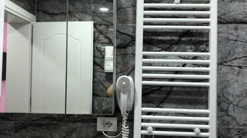 a bathroom with a hair dryer next to a mirror at Deluxe Apartment In City Center in Tirana