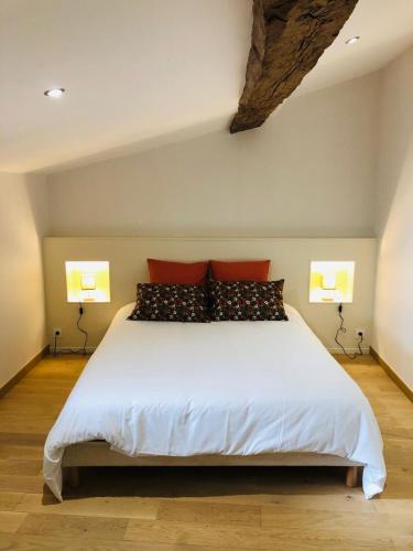 une chambre avec un grand lit blanc avec des oreillers rouges dans l'établissement La Magnanerie, à Montoison