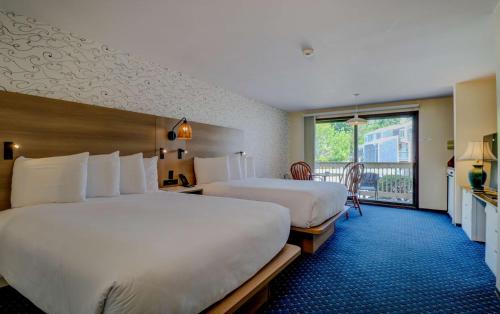 a hotel room with two beds and a balcony at Aspinquid Resort in Ogunquit
