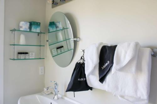 a bathroom with a sink and a mirror and towels at The Beach House Inn in Kennebunk