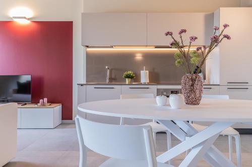 a kitchen with a white table and a vase with flowers at Verona Skyline Apartments - Appartamento 9D in Verona