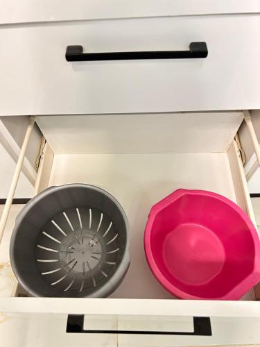 two bowls and a pink bowl in a drawer at Cosy Aparment near the sea in Hammamet