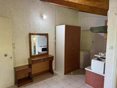 a small kitchen with a mirror and a refrigerator at Paris sea view studio in Platamonas
