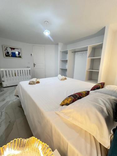 a bedroom with two large beds with white sheets at Cosy Aparment near the sea in Hammamet
