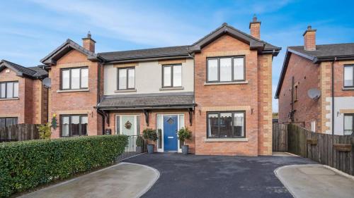 a large brick house with a blue door at Dun Na Caraige in Kingscourt