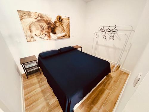a bed in a room with a picture of a cat at Apto 1 Leones con Wifi y Netflix in Alcobendas