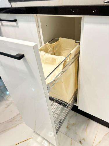 an open drawer in a white refrigerator with a shelf at Cosy Aparment near the sea in Hammamet