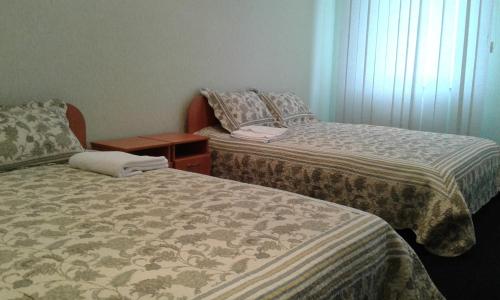 a room with two beds and a nightstand between them at Vershnyk in Cherkasy