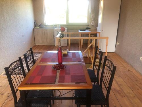 a dining room table with chairs and a table with a vase on it at Sweet Honey homestay in Jūrmala