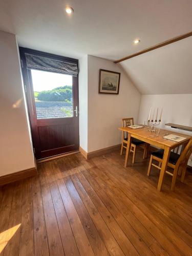 a dining room with a wooden table and a window at Stewards Granary in Cornhill-on-tweed