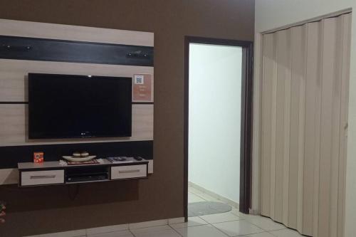 a living room with a flat screen tv on a wall at Cantinho do sossego in Sao Jose do Rio Preto