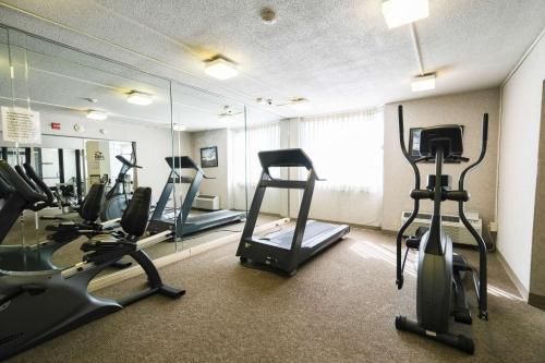 a gym with treadmills and ellipticals in front of a mirror at Fireside Inn & Suites Portland in Portland