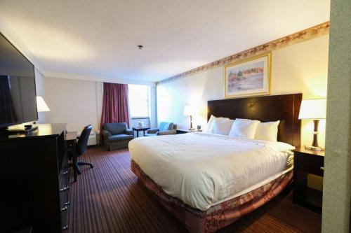 a hotel room with a bed and a television at Fireside Inn & Suites Portland in Portland