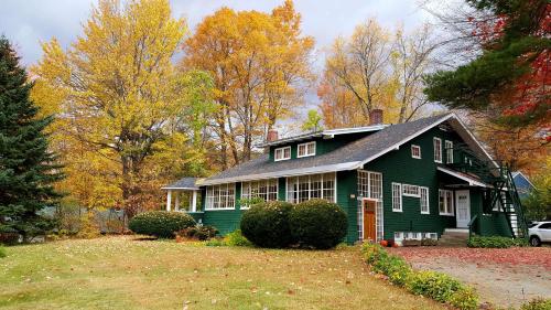 una casa verde en medio de un patio en Wilderness Inn Bed and Breakfast, en North Woodstock