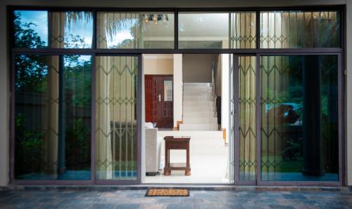 a glass door of a house with a chair inside at Su's Crest in Blantyre