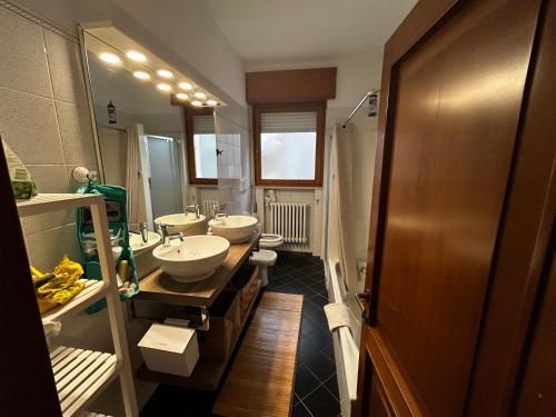 a bathroom with two sinks and two mirrors at Casa Cloe in Rimini