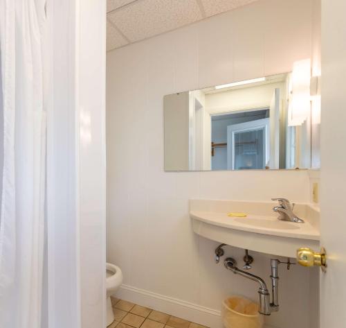a white bathroom with a sink and a mirror at The Gull Oceanside Inn & Motel in Old Orchard Beach