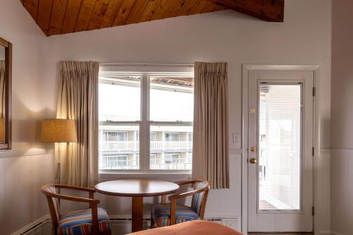 a room with a table and chairs and a window at The Gull Oceanside Inn & Motel in Old Orchard Beach