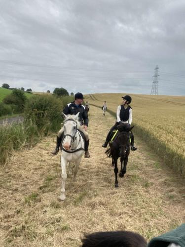 two people riding horses down a dirt road at Stewards Bothy in Cornhill-on-tweed