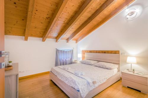 Un dormitorio con una cama y un techo de madera. en Stazione 200m - Wifi - Aria condizionata - Smart TV, en Parma