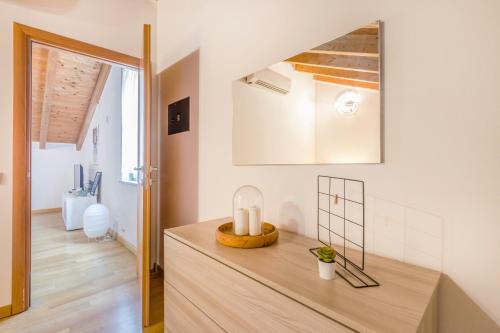 Habitación con mesa y espejo en la pared. en Stazione 200m - Wifi - Aria condizionata - Smart TV, en Parma