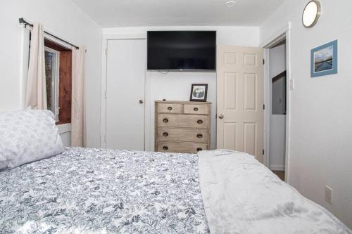 a bedroom with a bed and a dresser with a television at Meadow Rue Hideaway in North Pole