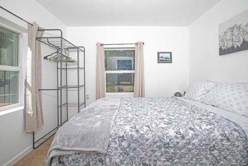 a white bedroom with a bed and a window at Meadow Rue Hideaway in North Pole