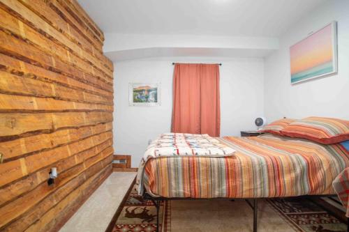 a bedroom with a bed and a wooden wall at Meadow Rue Retreat in Dennis Manor