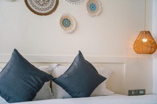 a bedroom with blue pillows on a bed at Catnip Seaside Hotel&Cafe in Ban Huai Luk (1)