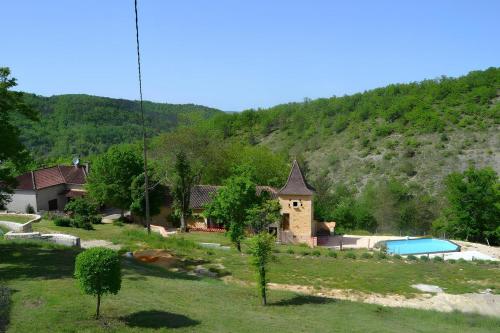 a house with a swimming pool and a mountain at Le Gindreau in Grézels