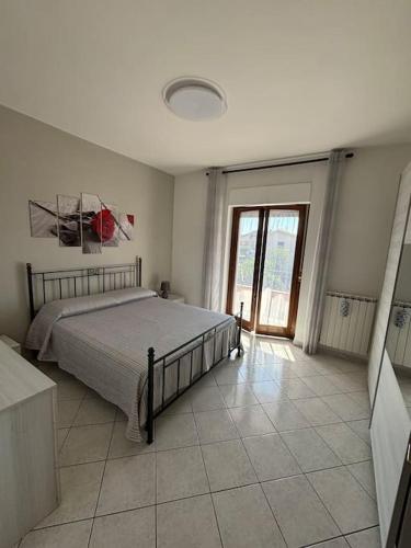 a bedroom with a bed and a large window at Sunshine Alloggio turistico in Capodimonte