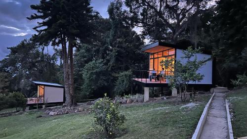 a house on a hill with a tree at Eco Lodge Los de Arriba en Lago Calima para dos personas in Restrepo