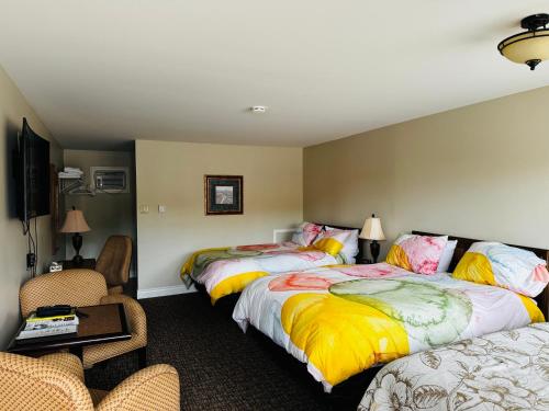 a hotel room with two beds and a tv at Fundy Line Motel in Miramichi