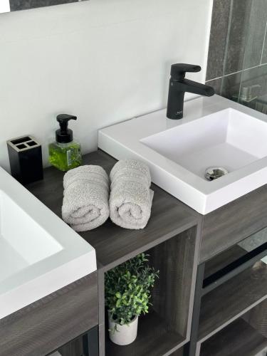 a bathroom with a sink and two towels at Eco Lodge Los de Arriba en Lago Calima para dos personas in Restrepo