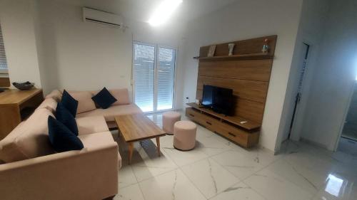 Una sala de estar con un sofá y un televisor. en Dea Apartament, en Golem