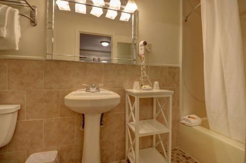 a bathroom with a sink and a toilet and a mirror at Senator Inn & Spa in Augusta