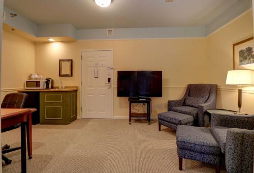 a living room with a flat screen tv and chairs at Senator Inn & Spa in Augusta