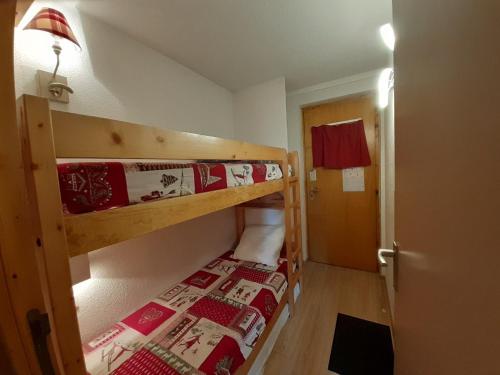 Cette petite chambre comprend 2 lits superposés et une porte. dans l'établissement Appartement 5 personnes à 50m des pistes avec balcon, parking et option Wi-Fi - FR-1-514-24, à Courchevel