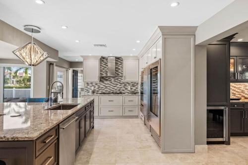a kitchen with white cabinets and granite counter tops at Peaceful Haven Waterfront Home Tierra Verde in Tierra Verde
