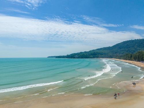 a group of people walking on the beach at Catnip Seaside Hotel&Cafe in Ban Huai Luk (1)