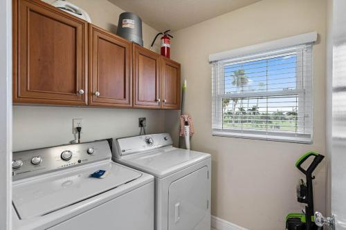 Un lavadero con lavadora y ventana. en New Listing Bahia Vista 8 411 2BD 2BA, en Tierra Verde