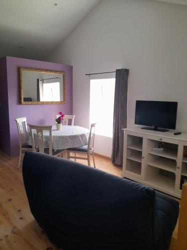 Il comprend un salon doté d'une télévision et d'une table avec des chaises. dans l'établissement Marillet, à Marillet
