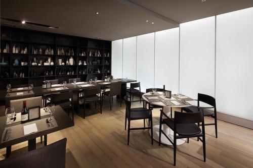 a restaurant with tables and chairs and wine bottles at Shilla Stay Guro - Guro Digital Complex Station in Seoul