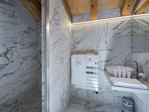 a bathroom with white marble walls and a sink at Duplex Montagne Spacieux avec Cheminée, 4 Chambres - FR-1-570-21 in Praranger