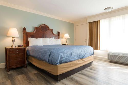 a bedroom with a large bed with a wooden headboard at Wonder View Inn in Bar Harbor
