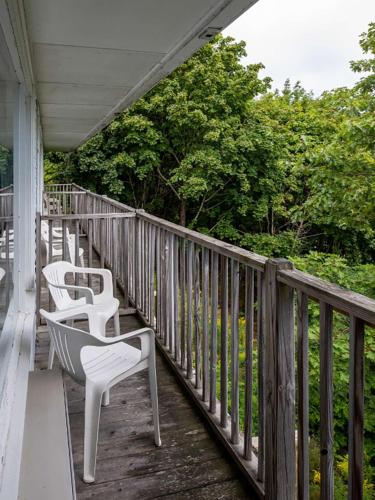 a row of white chairs sitting on a porch at Wonder View Inn in Bar Harbor