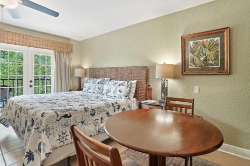 a bedroom with a bed and a table in a room at Beso Del Sol Beauty Studio Oasis in Dunedin 409 in Dunedin