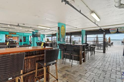 a restaurant with a bar and tables and chairs at Beso Del Sol Beauty Studio Oasis in Dunedin 409 in Dunedin